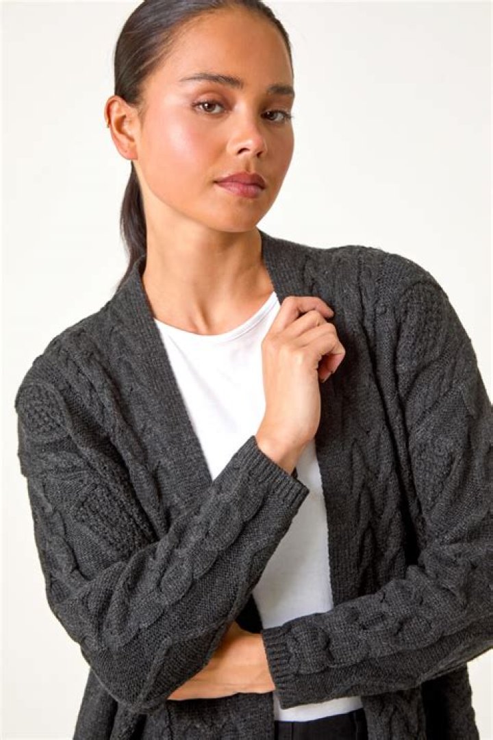 A light green cable-knit cardigan with decorative embroidery