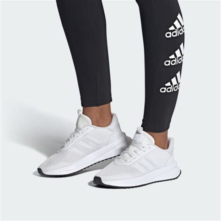 A white Adidas sneaker with green stripes