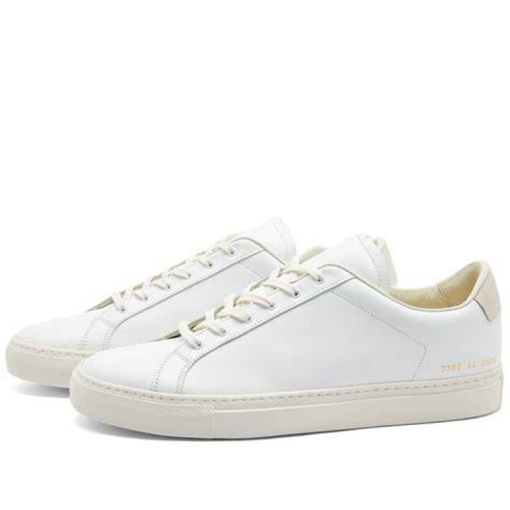 A white Common Projects mid-top sneaker