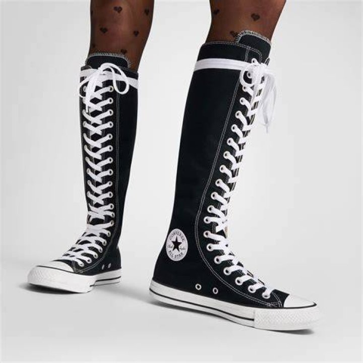 A white polka-dotted Converse high top sneaker with a red heart on it