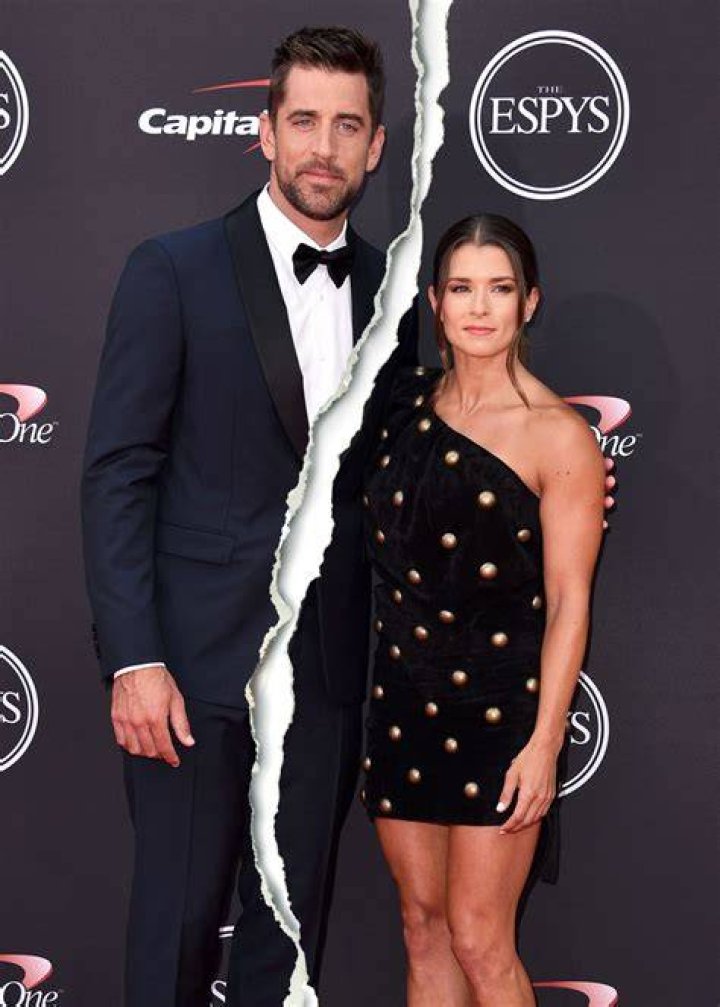 Aaron Rodgers and Danica Patrick looking at each other on a red carpet.