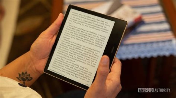Amazon Kindle Oasis in hand reading Amazon Kindle Oasis in hand reading