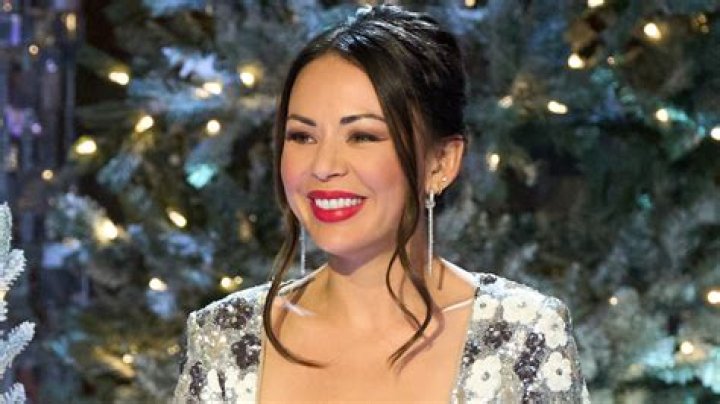 Janel Parrish standing at an event