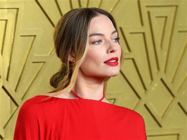 Margot Robbie wearing a red backless dress.