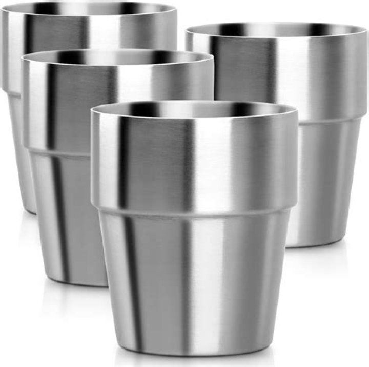 WeWork-6_metal cups water dispenser metal cups that read "WeWork" in front of a fruit-water dispenser.