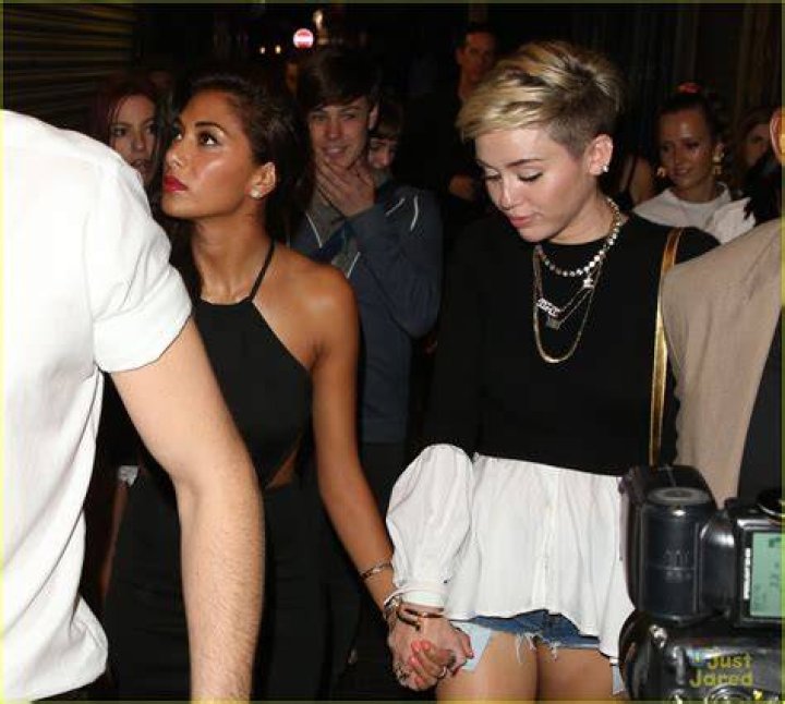 Miley Cyrus holds hands with girlfriend Stella Maxwell as they are seen